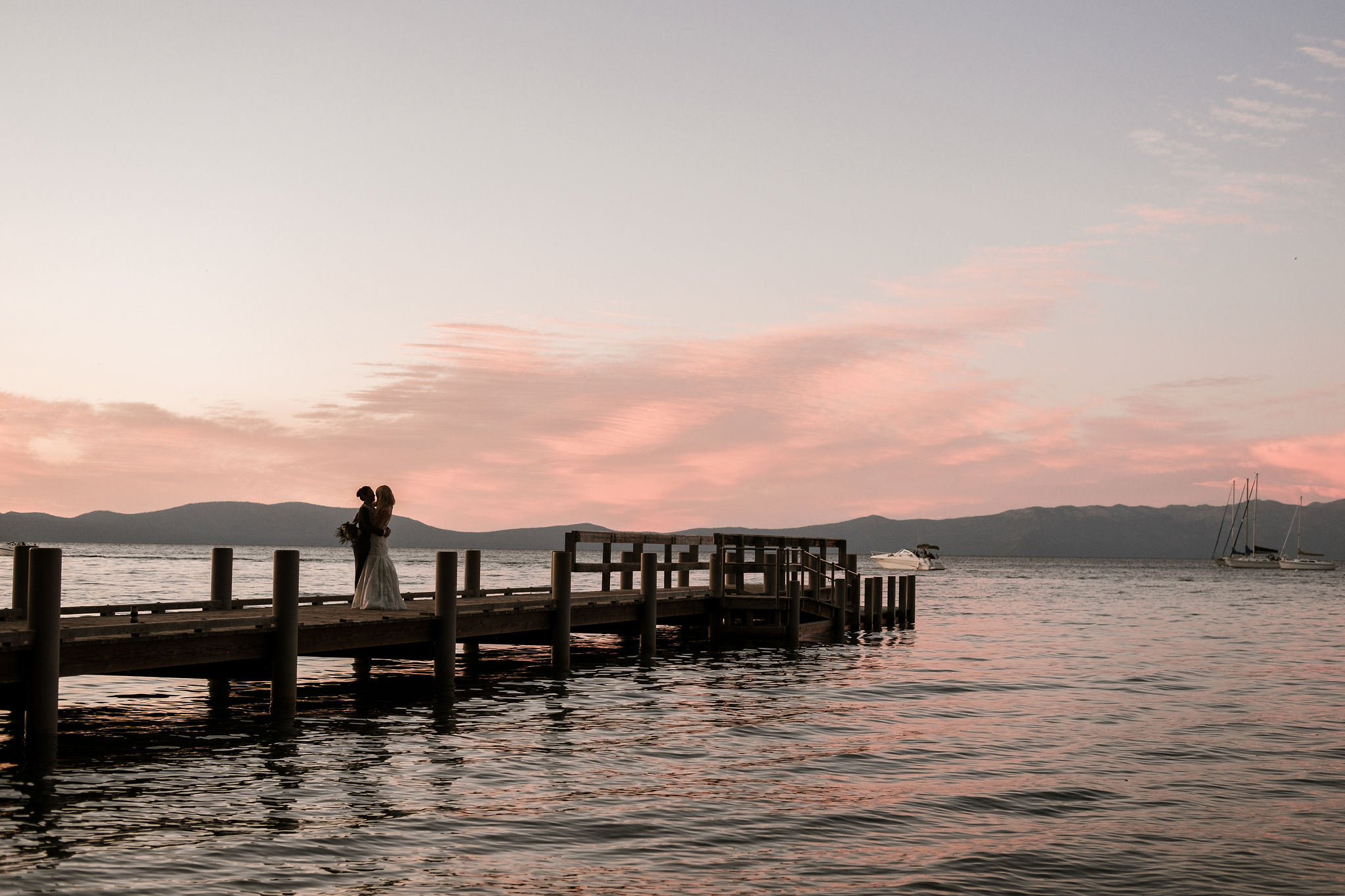 beautiful sunset as couple embraces on a dock on their wedding day