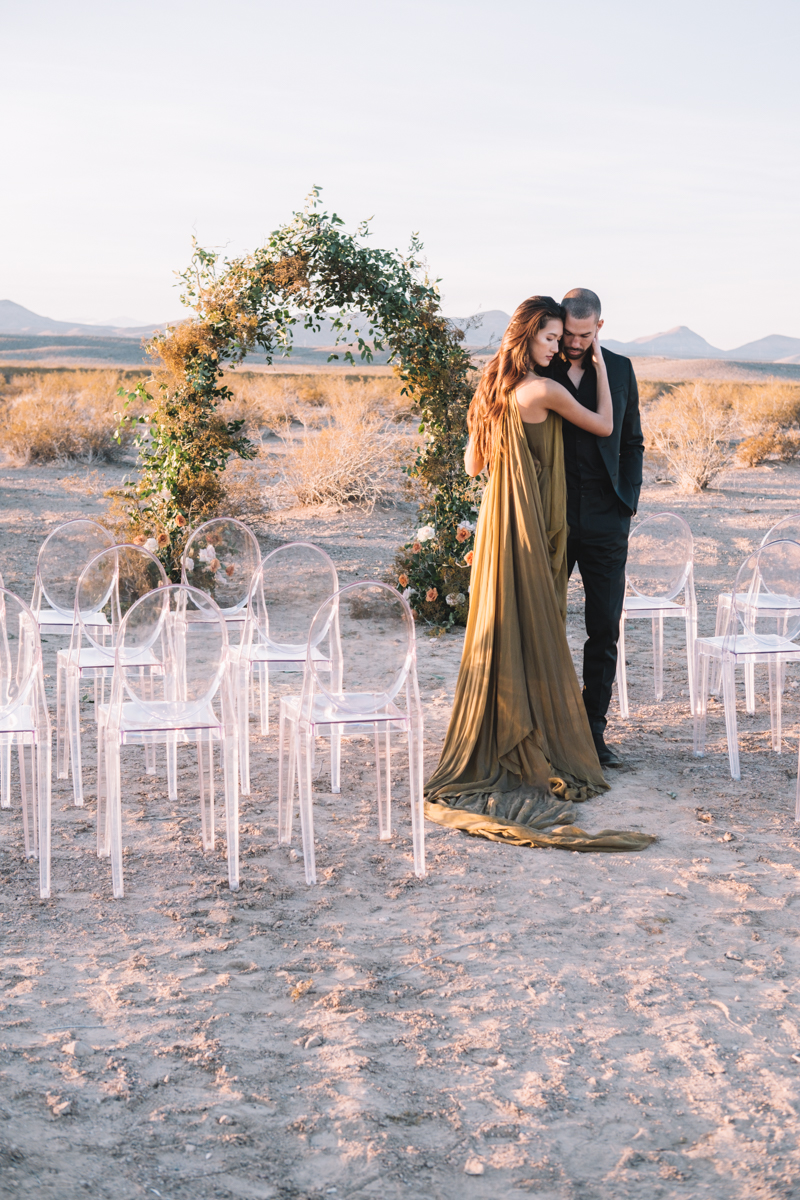 couple underneath floral arch in the desert