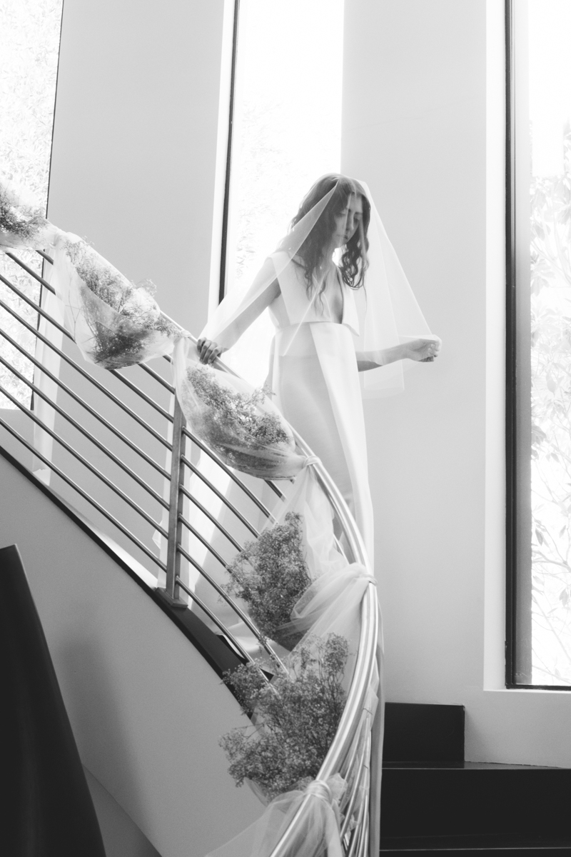 Bride descending down grand staircase on her wedding day
