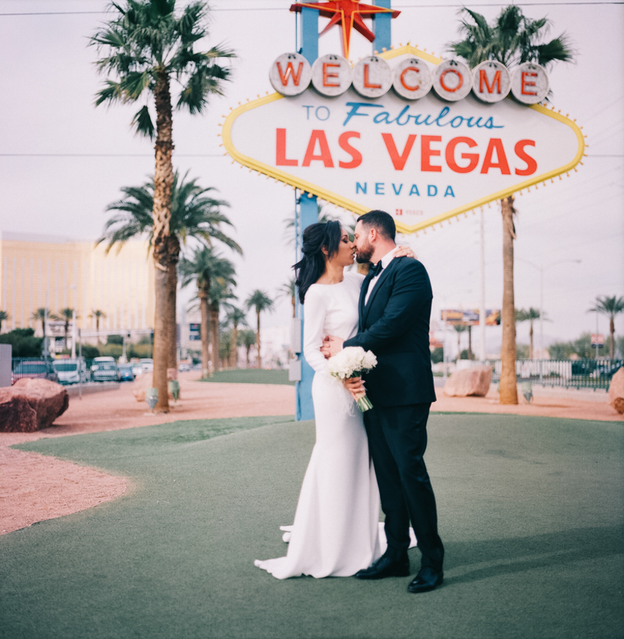 Beautiful Bride & Groom standing in front of Welcome to Las Vegas SIgn