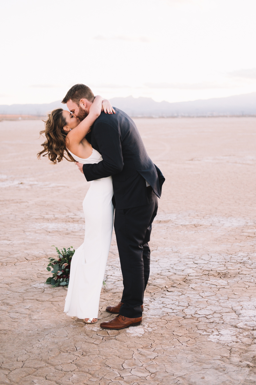bride and grooms first kiss in the desert