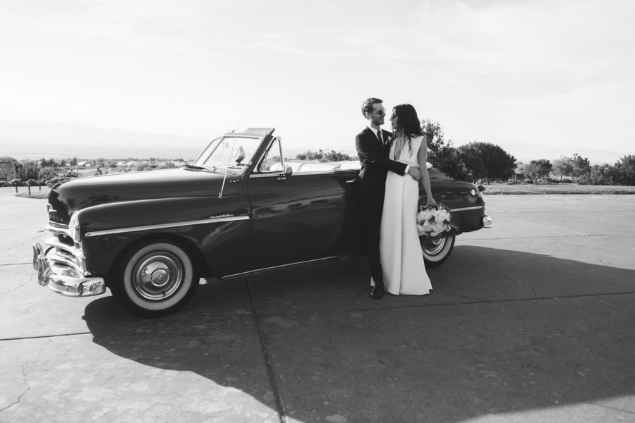 fashionable couple in front of classic car on wedding day